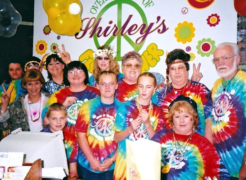 Team members celebrate Shirley's 25th anniversary with specially printed tie-dye shirts